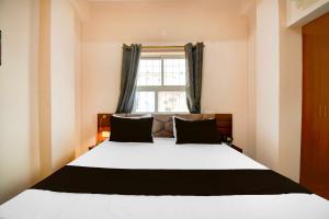 a bedroom with a large bed with a window at Collection O Collection O Kumhrar Archeological Park Hotel Karuna Palace in Patna