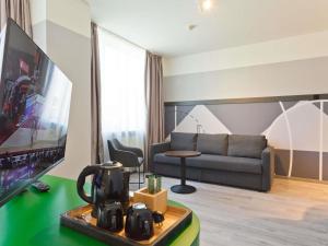 ein Wohnzimmer mit Sofa und Fernseher in der Unterkunft IBIS Styles Kaunas Centre in Kaunas