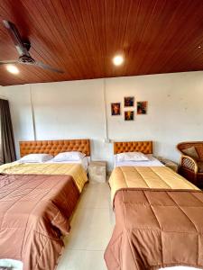 two beds sitting next to each other in a room at Vortex homes in Guwahati