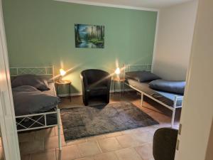 a room with two beds and a chair and lamps at LUTZ Appartements - Südheide in Gifhorn