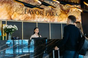 a man and a woman standing at a counter in a lobby at Favor Park Hotel in Kyiv +47 photos