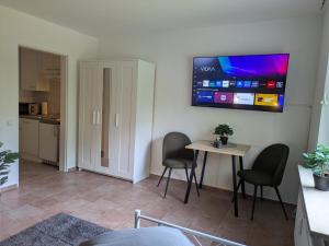 a living room with a table and chairs and a tv at LUTZ Appartements - Südheide in Gifhorn