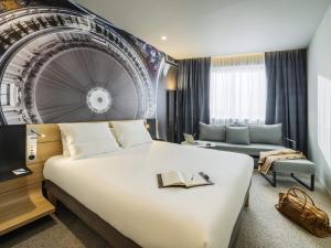 a hotel room with a large bed and a couch at Novotel Paris 20 Belleville in Paris +78 photos