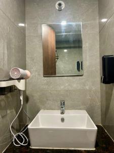 a white sink in a bathroom with a mirror at Anandam Luxury Hill View 1BHK in Pune in Pune +17 photos