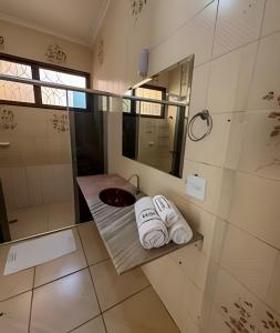 a bathroom with a sink and a shower and towels at Casa com piscina, área gourmet e espaço p/ festas in Ribeirão Preto +33 photos