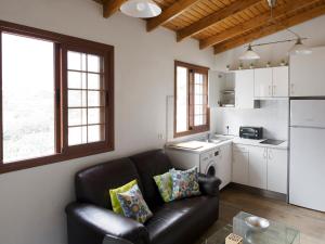 a living room with a leather couch and a kitchen at VV Casa Bibiana "by henrypole home" in Hermigua