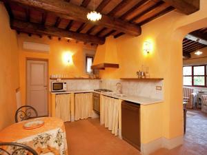 a large kitchen with yellow walls and wooden ceilings at Tuscan Charm in Greve in Le Bolle