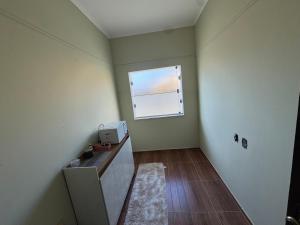 a small room with a window and a desk with a window at Quarto Família Aconchegante in Espirito Santo Do Pinhal