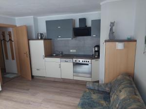 a kitchen with white cabinets and a stove top oven at Haus Holzer in Dorfgastein