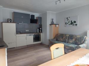 a living room with a couch and a kitchen at Haus Holzer in Dorfgastein