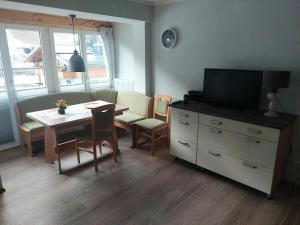a living room with a table and a tv and a dining room at Haus Holzer in Dorfgastein