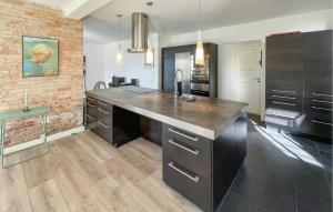 a kitchen with a black counter and a brick wall at 2 Bedroom Nice Home In Harpelunde in Harpelunde