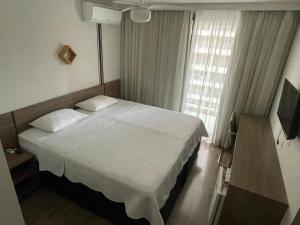 a bedroom with a white bed and a window at Via premiere in Rio de Janeiro