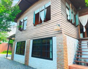 a brick house with windows and a staircase at Termcheewa Homestay in Chiang Rai