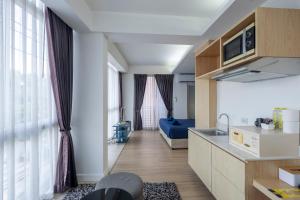 a kitchen and living room with a sink and a couch at GP House Express Sukhumvit 81 in Bangkok