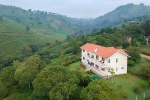 an aerial view of a house on a hill at 42 Green Pastures By Lexstays -Tea Estate Experience in Coonoor