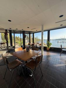a dining room with a table and chairs and the water at Hotel Airisto Marina in Pargas