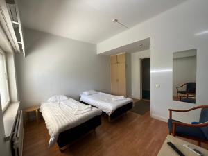 a room with two beds and a chair in it at Hotel Airisto Marina in Pargas