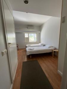 two beds in a small room with a window at Hotel Airisto Marina in Pargas +13 photos