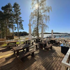 a group of picnic tables and umbrellas on a deck at Hotel Airisto Marina in Pargas