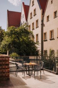 patio con sedie e tavolo di fronte a un edificio di The Cyrus Hotel a Breslavia