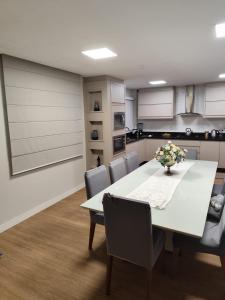 Un comedor con una mesa y sillas blancas. en Linda Casa centro de Bal Camboriú, en Balneário Camboriú