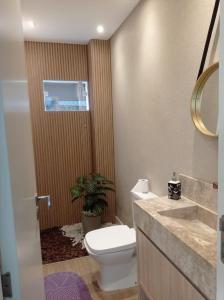 un baño con inodoro y lavabo en Linda Casa centro de Bal Camboriú, en Balneário Camboriú 29 fotos más