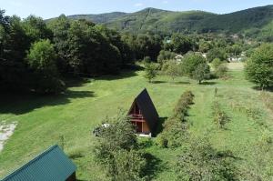 a cabin in a field with mountains in the background at Eco kutak 3 in Mojkovac