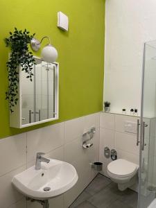 a bathroom with a sink and a toilet and a mirror at GreenOasis - Gepflegte & gemütliche Wohnung in bester Innenstadt Lage - in Cologne