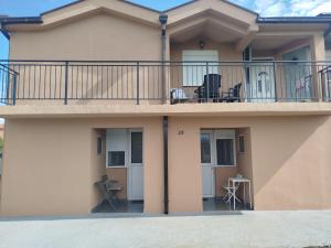 a house with a balcony with chairs on it at Apartment Filipovic in Podgorica