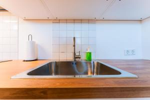 a stainless steel sink in the middle of a kitchen at Flex SelfCheckIns 146 - Zagreb - 1 Bedroom - Loggia - WIFI in Zagreb +12 photos
