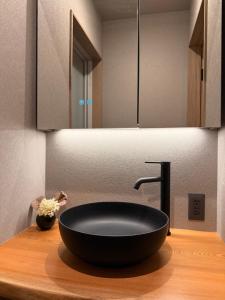 a bathroom with a black sink and a mirror at 玄Gen Private Villa in Takayama +26 photos