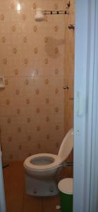 a bathroom with a white toilet in a room at Cantinho aconchegante in Praia Grande