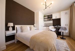 Un dormitorio con una cama grande y un escritorio. en NEST SUITE Studio Flat in North London, en Londres