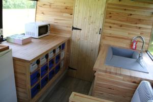 a kitchen with a sink and a microwave at Baie de Somme Bus in Saint-Blimont