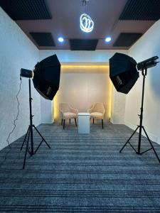 una stanza con due telecamere, un divano e delle sedie di Intelzaa Studio 