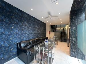 a dining room with a leather couch and tables at Hotel Rexton Inn in Mumbai