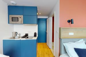 une petite cuisine avec un évier et un micro-ondes dans l'établissement Bale 94 CoLiving - Self Check In by Homenhancement, à Saint-Louis 19 autres photos