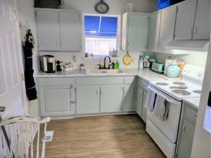 a kitchen with white cabinets and a sink at COZY-Quiet Cottage Pets Kitchen in Tallahassee