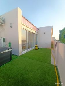 a yard with green grass in a house at Large Apartment, Sea View, Jacuzzi & Family Games in Fort de lʼEau