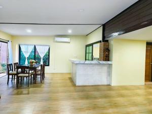 a dining room with a table and chairs and a kitchen at Termcheewa Homestay in Chiang Rai