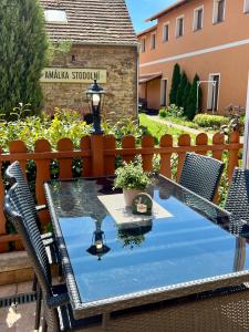 ein Glastisch mit Stühlen und einer Lampe auf einer Terrasse in der Unterkunft Amálka u Řípu in Straškov