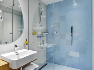 a bathroom with a sink and a glass shower at ibis Styles Kraków Centrum in Kraków +71 photos