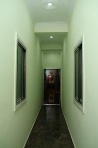 an empty hallway with green walls and two windows at Hotel Avtar Palace in Jāmb +1 photo