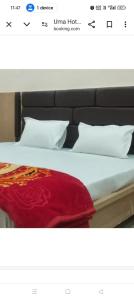 a bed with a red blanket and white pillows at Hotel Avtar Palace in Jāmb