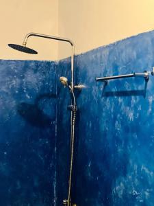 a bathroom with a shower with a blue wall at Jungle Restaurant and Villa in Unawatuna