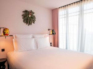 a bedroom with a white bed and a window at Mama Shelter Lisboa in Lisbon