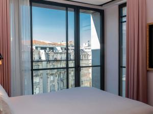a bedroom with a large window with a view of the city at Mama Shelter Lisboa in Lisbon +225 photos