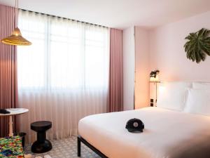 a hotel room with a bed with a hat on it at Mama Shelter Lisboa in Lisbon