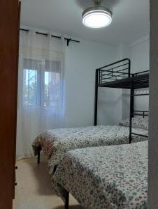 a bedroom with two bunk beds and a window at Habitación Cama Literas Mixta Castilleja de la Cuesta in Castilleja de la Cuesta